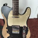 Elektrická kytara typu Telecaster s přírodním dřevěným povrchem těla a hnědým hmatníkem. Tělo je atypicky polepeno černou vrstvou barvy nebo fólie s…