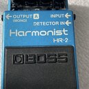 Modrý efekt pedál s černým gumovým spínacím tlačítkem. Na horní části je nápis Harmonist HR-2 a logo BOSS. Zařízení má čtyři ovládací knoflíky a tři…