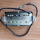 Elektrický snímač kytary v kovovém krytu s připojeným černým kabelem a vyvedenými barevnými vodiči. Na spodní straně je vyražen nápis Seymour Duncan…