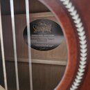 Detail znamení uvnitř ozvučovacího otvoru akustické kytary. Na černém oválném štítku je bílý nápis Seagull, pod ním text Fabriqué au Canada - Made In…