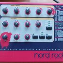 Červený rackový syntetizátor s nápisem nord rack 2 virtual analog a textem VIRTUAL ANALOG SYNTHESIZER MADE IN SWEDEN BY CLAVIA. Přední panel obsahuje…