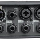 Černý elektronický přístroj s řadou konektorů a ovládacích prvků. Na panelu jsou nápisy Master, Outputs, Aux, Line IN a Preamp OUT u jednotlivých výs…