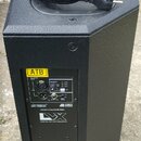 Černý aktivní reproduktor s texturovaným povrchem. Na zadním panelu jsou nápisy ATB, BALANCED INPUT, SENSITIVITY, DESIGNED & DEVELOPED IN ITALY, dB t…