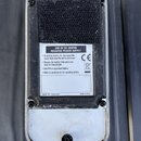 Zadní strana stříbrného efektpedálu s černým suchým zipem v horní části. Na bílém štítku je nápis USE 9V DC CENTRE NEGATIVE POWER SUPPLY, symbol CE a…