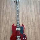 Červená elektrická basová kytara s tmavým hmatníkem a černým pickguardem. Na hlavě je bílý nápis Epiphone. Nástroj má dva snímače a čtyři ovládací kn…