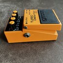 Oranžový efekt pedál s černým spínacím tlačítkem. Na horní straně je nápis TURBO Distortion DS-2 a logo BOSS. Zařízení má čtyři černé ovládací knoflí…