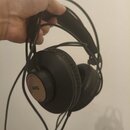Černé centerXlupující sluchátka s kabelovým připojeními. Na vnější straně levého sluchátka je vidět loga AKG a pod ním označení K72. Povrch sluchátek…