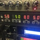 Detailní pohled na rackové studio vybavení. Horní jednotka má stříbrný povrch s několika chromovanými oválnými knoflíky a nápisy SOLO CHANNEL, 1, 3 a…