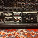 Detail zadního panelu kytarového zesilovače s nápisem TRIREC INFINIUM. Panel obsahuje ovládací prvky Line Out Level, přepínač Impedance (16, 8, 4), v…