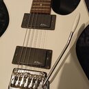 Bílá elektrická kytara s hnědým hmatníkem a dvěma černými humbuckery. Na obou snímačích je bílý nápis BC Rich. Nástroj má chromovaný tremolo systém s…