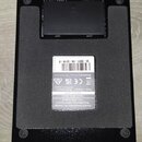 Fotografie zachycuje spodní stranu černého elektronického zařízení. Na stříbrném štítku jsou uvedeny nápisy: Marshall Amplification Plc, Derbyshire,…