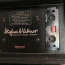 Záběr na zadní panel černého hudebního zařízení. Je zde vidět nápis Hughes & Ketturner® a text MADE IN ST. WENDEL GERMANY. Panel obsahuje dva MIDI ko…