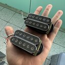 Dvě elektrické snímače typu humbucker v černé barvě s chromovanými kryty. Na krytech nejsou žádné viditelné značky ani nápisy. Snímače mají připojené…
