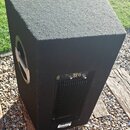 Černý aktivní subwoofer v kostkovém korpusu potažený texturovaným povrchem. Na zadním panelu je vidět nápis Pro X, ovládací prvky a konektory. V doln…