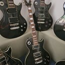 Černá elektrická kytara typu Les Paul se značkou Gibson na hlavě. Nástroj má hnědý hmatník s bílými blokovými vložkami a chromované potenciometry a l…
