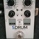 Bílý efekt pedál s nápisy GROOVE KIT, HATS/RIDES a značkou SDRUM Strummable Drums™. Zařízení má dva černé otočné knoflíky, pět malých LED indikátorů…