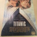 Fotografie znázorňuje obal singlu nebo soundtracku s nápisem MY HEART WILL GO ON a podtitulem LOVE THEME FROM TITANIC. Uprostřed je velký bílý nápis…