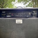 Zadní strana černého kytarového komba s texturovaným povrchem. V horní části je nápis TNT a logo Peavey, vlevo dole text ASSEMBLED IN USA. Na zadním…