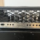 Zadní strana kytarového komba s černou mřížkou, za kterou jsou vidět čtyři elektronky. Na spodním panelu je nápis EFENDI SOUND HARDWARE - Handbuilt i…