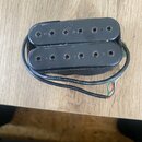 Černý humbucker s dvěma řadami magnetických pólů. Snímač je umístěn v černém plastovém rámečku a má přivedený kabel s nápisem 28AWG/1/C N AWM 2651. P…