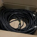 V kartonové krabici je smotaný černý kabel s konektory XLR. Na povrchu kabelu je nápis LOW NOISE CABLE a na jednom z konektorů je viditelné logo NEUT…