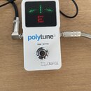 Bílý ladicí pedál s černým displejem, na kterém svítí zelené a červené kontrolky. Na spodní části je modrý nápis polytune3, pod ním text TRUE | BUFFE…