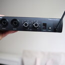 Černý přenosný mixér s nápisem SHURE® vlevo a PSM200 TransMixer vpravo. Zařízení má dva vstupy MIC/LINE 1 a MIC/LINE 2, dva ovratové knoflíky s popis…