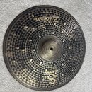 Kruhový činel s výraznou strukturovanou povrchovou úpravou v tmavě zlaté a černé barvě. Na povrchu je nápis Zildjian a dále označení Dark Crash s vyr…