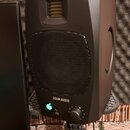 Černý studiový monitor značky ADAM AUDIO umístěný na černém stojanu. Reproduktor má v horní části vřetenový výšek a uprostřed velký textilní kryt mem…