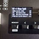 Detailní pohled na ovládací panel černého klávesového nástroje. Digitální displej zobrazuje text „02-4 Atmo Split“ a seznam zvuků: „ORG B3 1956 60“,…