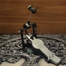 Kovový pedál basového bubnu v stříbrné a černé barvě. Na stupni je vyražen nápis "BOSSA". Mechanismus obsahuje řetězový pohon a nastavitelné části. P…
