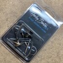 Plastové balení s kovovými popruhovými zámky a šrouby. Na černém podkladu je bílý nápis Harley Benton PARTS a modrý text STRAP SECURITY LOCKS. Ve spo…