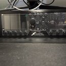 Černý rackový procesor s nápisem FRACTAL AUDIO SYSTEMS a označením AXE-FX III PREAMP/FX PROCESSOR - MARK II. Zařízení má vlevo displej, řadu ovládací…