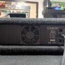 Zadní strana černého kytarového komba v textilním potahu. Na zadním panelu je nápis CARVIN R600, PROFESSIONAL REDLINE STEREO POWER AMP a sériové čísl…