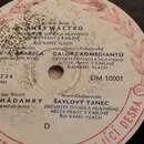 Detailní záběr na středový štítek vinylové desky v bílo-červené barvě. Štítek obsahuje texty: SMĚS WALTZŮ, JOE A ARABELA, GALOP Z KOMEDIANTŮ, TŘI HÁD…