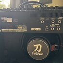 Zadní strana černého kytarového komba. Na horním panelu jsou nápisy Roland, MODEL: KTN-100 a SERIAL NO: DJ29716, dále značka BOSS a konektory s popis…