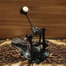 Černý bicí pedál s kovovými a plastovými prvky. Na mechanismu není vidět žádný značkový nápis ani logo. Pedál vykazuje mírné známky používání a povrc…