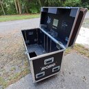 Černý transportní flightcase z překlijek s hliníkovými hranami a kovovými pojišťovacími prvky. Na přední straně je bílý nápis ROBE a v horní části ví…