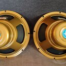 Dva stejné reproduktory s golden-zlatým kovovým rámem a středovou částí. Na středovém krytu je modro-bílá nálepka s nápisy CELESTION, G5.0 ALNICO a G…