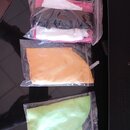 Tři průhledné plastové zip sáčky, v nichž jsou umístěny látkové utěrky. Horní sáček obsahuje růžovou a bílou utěrku, prostřední oranžovou a spodní ze…