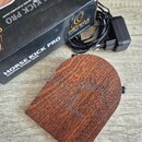 Hnědý dřevěný digitální stomp box s vyrytým nápisem HORSE KICK PRO a siluetou koně. Vedle nástroje je černý napájecí adaptér s kabelem a originální č…