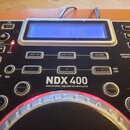 Černý stolní CD/MP3 přehrávač s modrým LCD displejem a stříbrnými prvky. Na předním panelu je bílý nápis NDX 400 a pod ním text PROFESSIONAL TABLETOP…