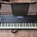 Černý digitální klavír Roland G-800 v černém polstrovaném pouzdře. Na levé straně je nápis Roland G-800 a pod ním text 64 VOICE POLYPHONY. Přístroj o…
