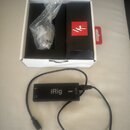 Černý audio rozhraní iRig HD 2 s připojeným kabelem a konektorem Lightning. Na zařízení je bílý nápis iRig a svisle orientovaný text HD 2. Vedle nást…
