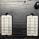 Detail korpusu elektrické kytary v černé barvě s výraznou strukturou dřeva. Nástroj má dva humbuckery se stříbrnými kryty a jeden černý ovládací knof…