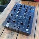 Černý dvoukanálový DJ mixér s nápisem Pioneer DJ DJM-450. Zařízení obsahuje řadu potenciometrů, posuvníků a tlačítek s označením jako SOUND COLOR FX,…