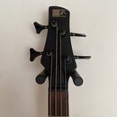 Černý hlavník basové kytary s nápisem SDR a textem SOUNDGEAR BY IBANEZ. Nástroj má čtyři ladicí kolíky v černé barvě a čtyři struny. Povrch je matně…