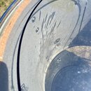 Detailní pohled do vnitřku bubnu s anodizovaným stříbrným povrchem korpusu. Na vnitřní stěně jsou vidět četné škrábance a oděrky. V dolní části je čá…