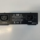 Zadní strana černého elektronického zařízení s kovovým povrchem. Jsou zde vidět dva konektory, nápisy „200 WATTS MAX“ a „220-240VAC“, značka „CE“ a t…