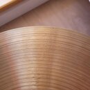 Detailní pohled na povrch mosazného činele s koncentrickými rýhami. Na povrchu je vyražen nápis „Zildjian“, pod ním slovo „AVEDIS“ a dále text „MADE…